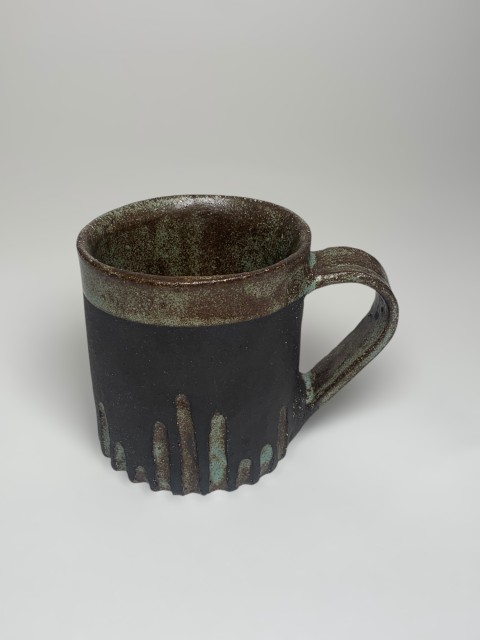 Taza pasta negra. Interior y bajorelieve esmeralda. Exterior pasta expuesta